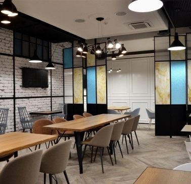 Honey in Kyiv - dining space with soft seats and colored glass partitions