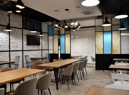 Honey in Kyiv - dining space with soft seats and colored glass partitions