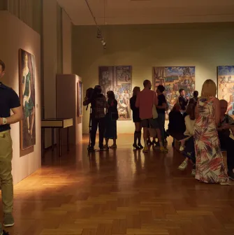 Natsionalnyi Khudozhnii Muzei Ukrainy in Kyiv - elegant exhibition room with burgundy walls covered in framed classic paintings and antique