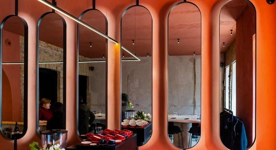 Designer mirror wall decoration at Pure & Naive restaurant in Kyiv with orange interior