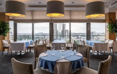 City Hotel in Kyiv - panoramic restaurant with set tables and large drum pendant lamps