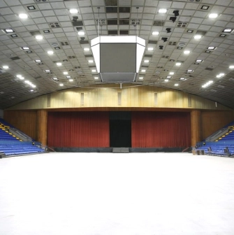 Palats Sportu in Kyiv - vast empty white arena floor leading to a stage concealed by heavy red curtains