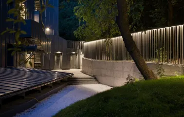 Teatr na Podoli in Kyiv - atmospheric outdoor courtyard with a concrete path and stairs illuminated by soft linear lights at night