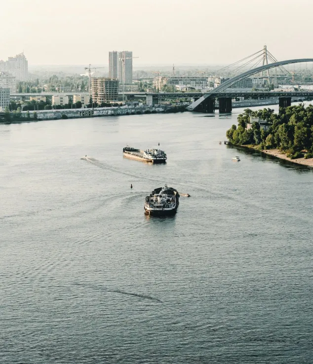 Two boats cruising along the Dnipro River in Kyiv