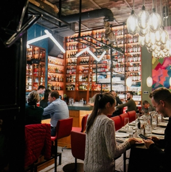 Restaurant Italiiska Redaktsiia - lively dining area with a high bar counter and guests seated at tables