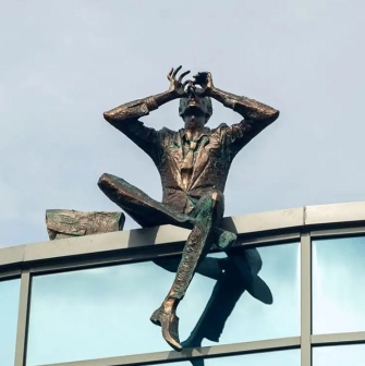 Sculpture of a man with binoculars on the roof of a modern building near Mariinsky Park in Kyiv