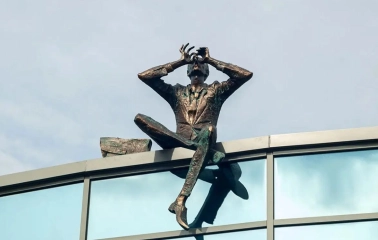 Sculpture of a man with binoculars on the roof of a modern building near Mariinsky Park in Kyiv