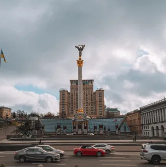 Independence Monument in Kyiv - wide view of the Independence Monument and city traffic