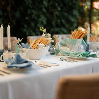 A table set for dinner with candles, breadsticks, and soft blue napkins