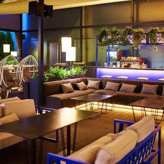 Par Bar - terrace with sofas and hanging chairs near bar counter