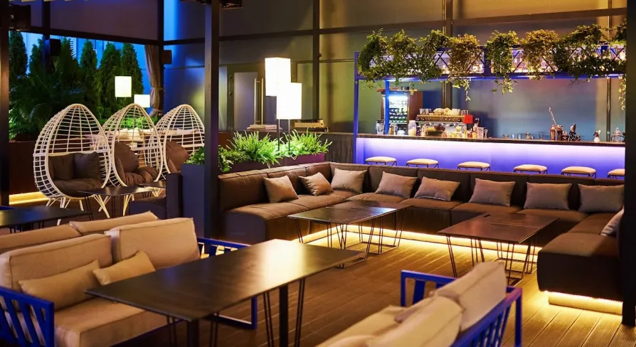 Par Bar - terrace with sofas and hanging chairs near bar counter