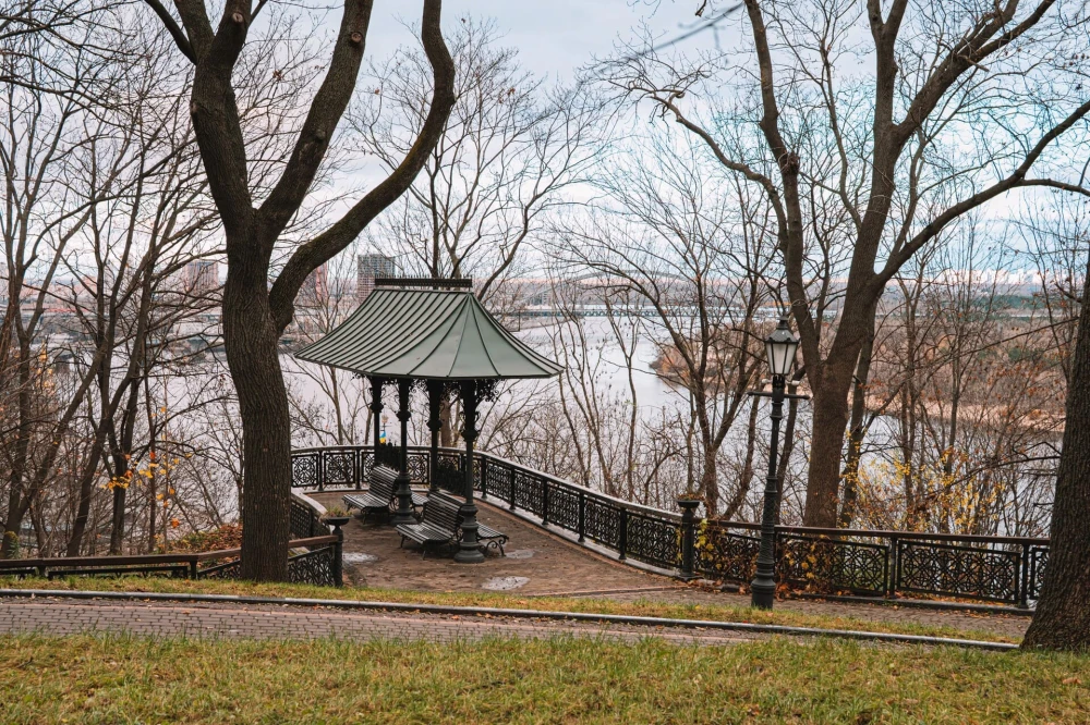 Volodymyrska Hill in Kyiv - metal gazebo and river view through the trees