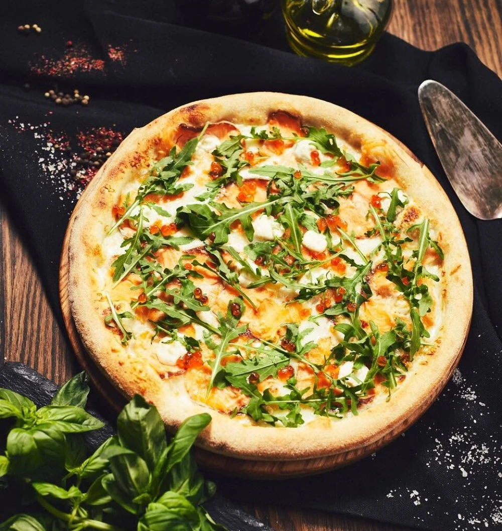 Pizza with greens and cheese at Veterano Pizza
