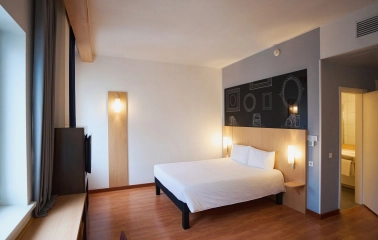 Ibis Railway Station in Kyiv - bedroom with white bed and black wall sketch