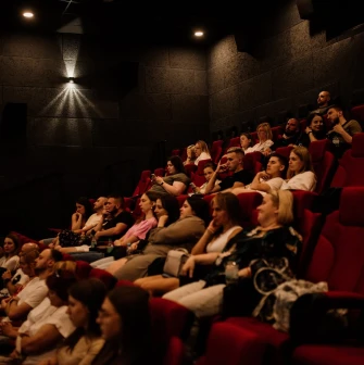 Spectators in red armchairs in the Cinema Citi movie theater