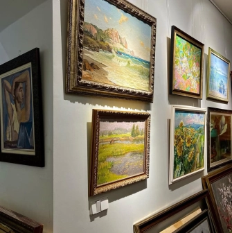 Paintings of different genres on the wall in L'Art Gallery in Kyiv