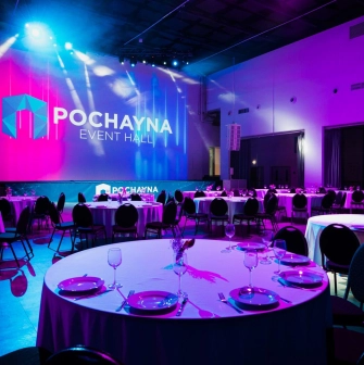 Hall for a gala dinner at Pochayna Event Hall in Kyiv with served tables