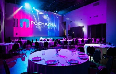 Hall for a gala dinner at Pochayna Event Hall in Kyiv with served tables