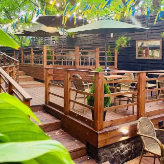 Outdoor restaurant terrace with wooden tables and yellow-blue ribbons