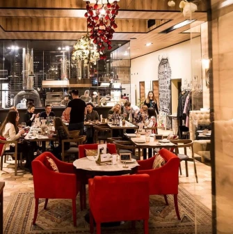 Restaurant Mama Manana - dining hall with guests and red armchairs