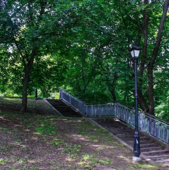Khreshchatyi Park in Kyiv - stone staircase with railings leading up a shaded hill with a street lamp