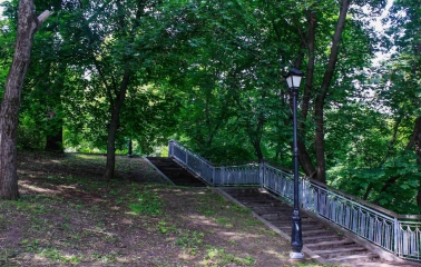 Khreshchatyi Park in Kyiv - stone staircase with railings leading up a shaded hill with a street lamp
