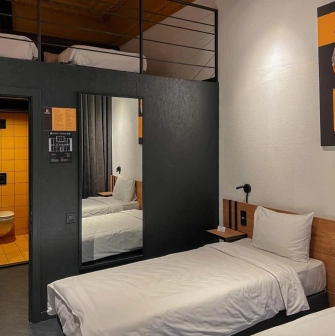 Modern interior of a room at the Globe Runner hostel in Kyiv with two beds and a mezzanine