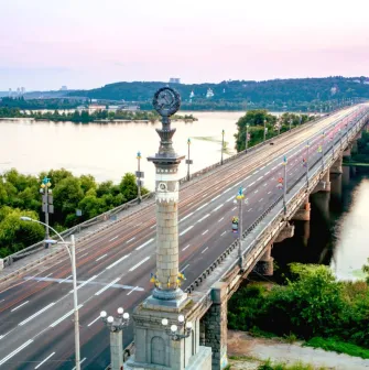 Paton Bridge in Kyiv with a distinctive decorative column in the foreground.