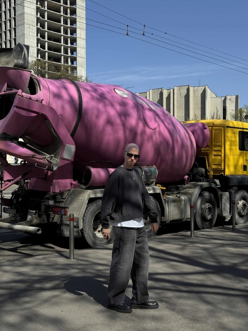 Matush Krayniak stands against the backdrop of a concrete mixing machine in Kyiv