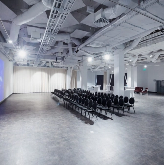 The large Pochayna Event Hall in Kyiv with a screen for projections and seating for the audience