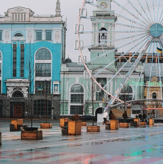 Kontraktova Square in Kyiv - ferris wheel next to a historic blue and white building