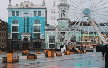 Kontraktova Square in Kyiv - ferris wheel next to a historic blue and white building