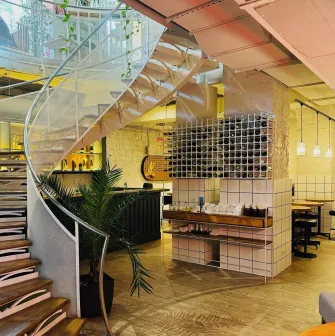 Restaurant Trishky Bilshe - interior view of a spiral staircase next to a wine rack display