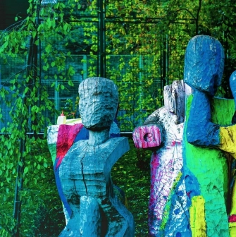 Samosad in Kyiv - artistic rough-hewn wooden sculptures painted in bright colors standing amongst the greenery