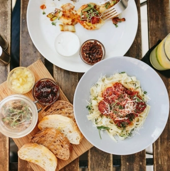 Bar Restaurant Kosatka - overhead shot of pasta bread and appetizers on an outdoor table