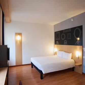 Ibis Railway Station in Kyiv - bedroom with white bed and black wall sketch