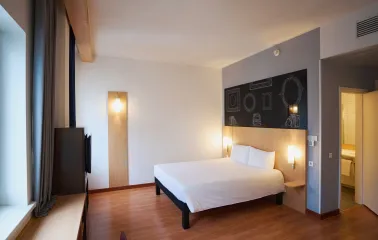 Ibis Railway Station in Kyiv - bedroom with white bed and black wall sketch