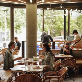 Takava in Kyiv - bright dining area with rattan chairs and large glass windows