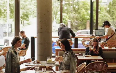 Takava in Kyiv - bright dining area with rattan chairs and large glass windows