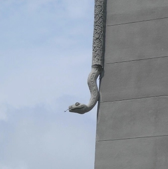 Budynok Horodetskoho in Kyiv - stone python sculpture crawling down the building corner
