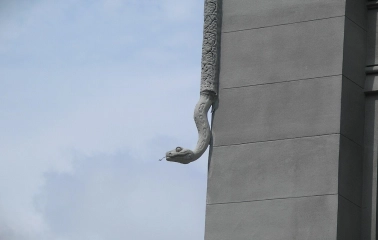 Budynok Horodetskoho in Kyiv - stone python sculpture crawling down the building corner