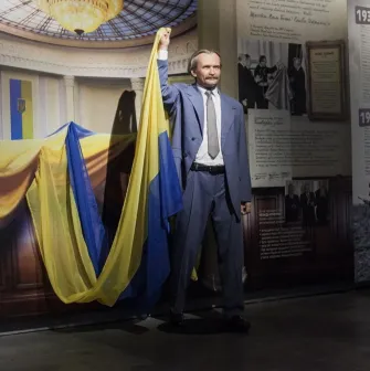 Muzei Stanovlennia Ukrainskoi Natsii in Kyiv - wax figure of Viacheslav Chornovil in a grey suit enthusiastically raising the Ukrainian flag