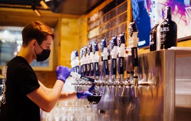 Pub Varvar bar - bartender standing behind the bar preparing drinks with tap handles visible