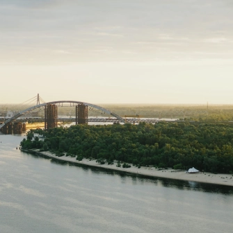 Dnipro river - view of the Podilsko-Voskresensky Bridge arch and sandy beach