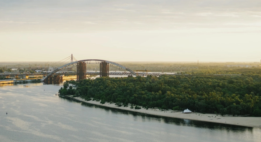 Dnipro river - view of the Podilsko-Voskresensky Bridge arch and sandy beach