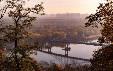 Dnipro river - pedestrian bridge to Trukhaniv Island framed by autumn trees