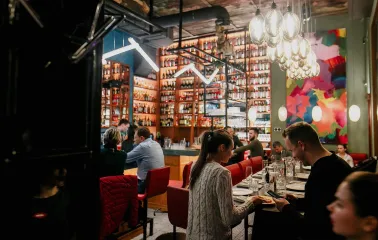 Restaurant Italiiska Redaktsiia - lively dining area with a high bar counter and guests seated at tables