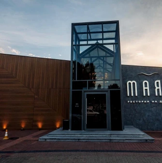 Mayak - modern restaurant facade with glass entrance and wooden panels