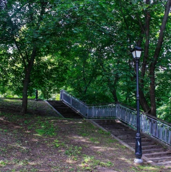 Khreshchatyi Park in Kyiv - stone staircase with railings leading up a shaded hill with a street lamp