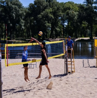 X-Park in Kyiv - active game of beach volleyball on a sandy court near the water
